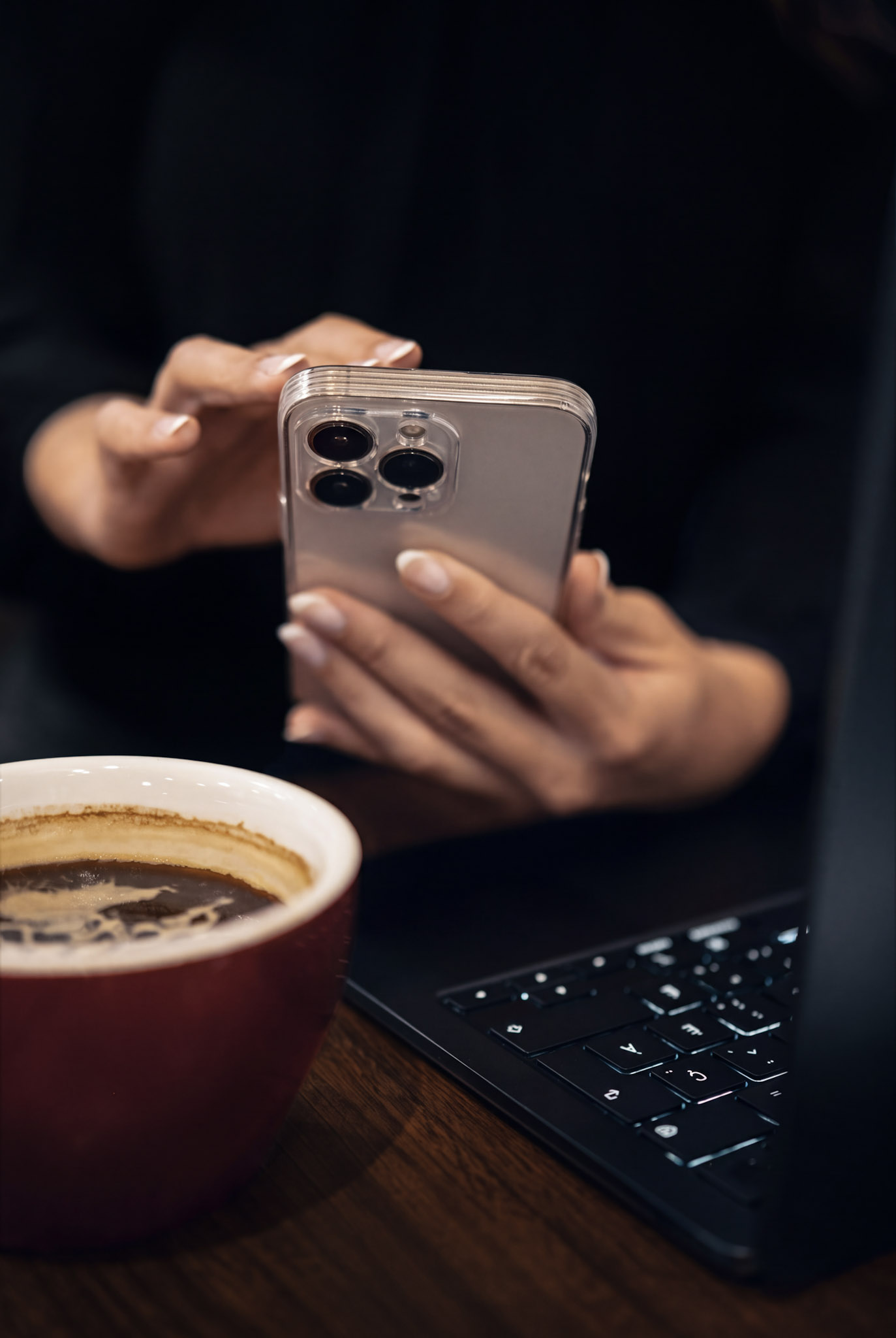 Mains tenant un téléphone à côté d'un café